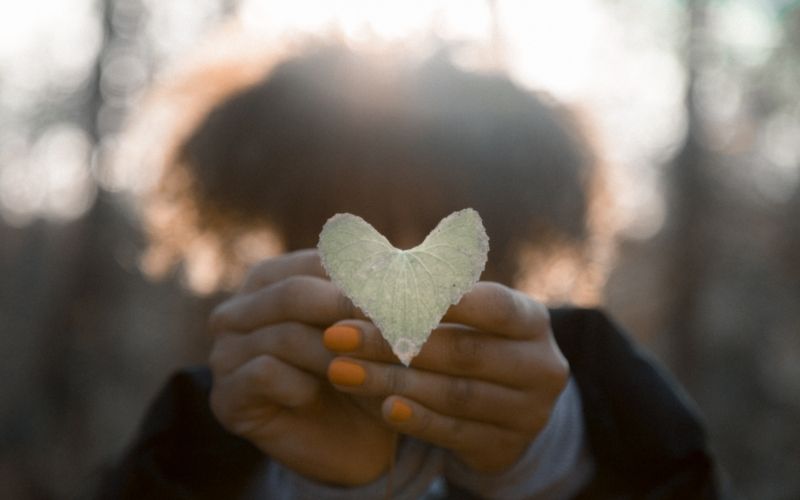 woman holding heart shaped leaf
